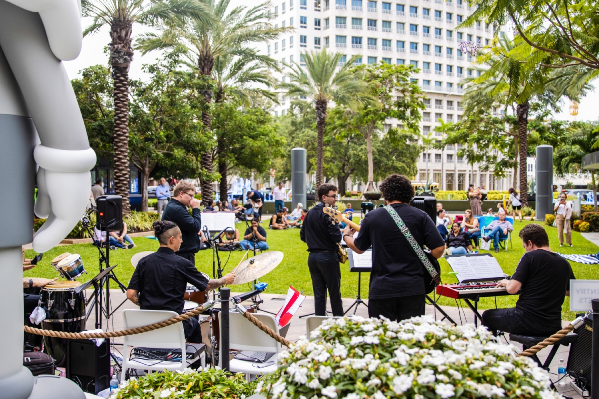 Shot of band playing in front of modern art from behind.