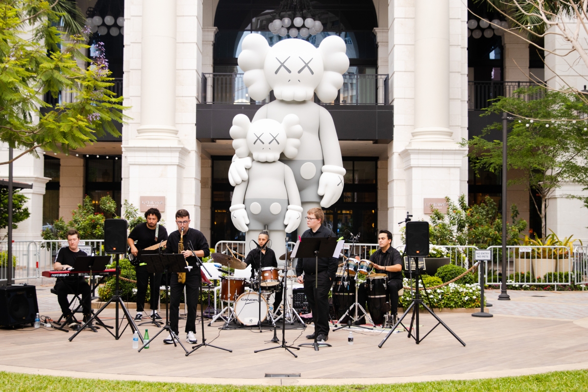 Band playing in front of Kaws Modern Art